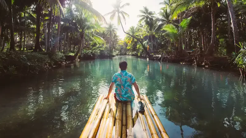 selva-da-palmeira-nas-filipinas-conceito-sobre-viagens-tropicais-desejo-por-viajar-balancando-no-rio-pessoas-se-divertindo